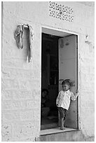 Young boy in doorway of house painted light blue. Jodhpur, Rajasthan, India ( black and white)
