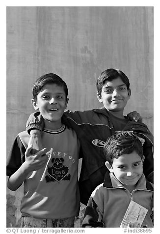 Young boys in front of blue wall. Jodhpur, Rajasthan, India (black and white)