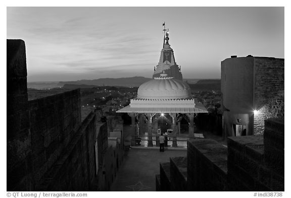 Chamunda Devi temple with man worshipping at sunset, Mehrangarh Fort. Jodhpur, Rajasthan, India (black and white)