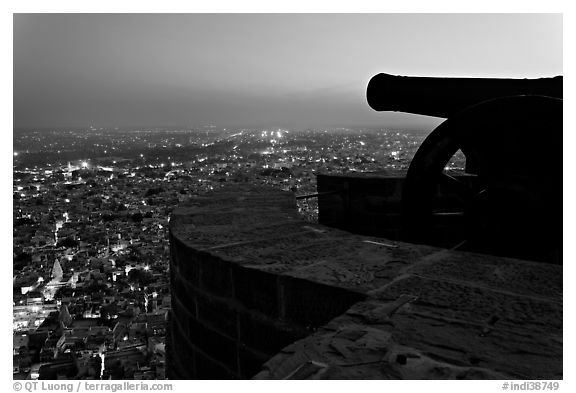 Cannon on top of Mehrangarh Fort, and city lights below. Jodhpur, Rajasthan, India (black and white)