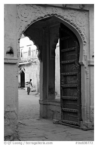 Archway with woman carrying water in courtyard. Jodhpur, Rajasthan, India