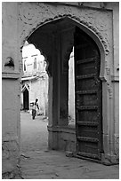 Archway with woman carrying water in courtyard. Jodhpur, Rajasthan, India (black and white)