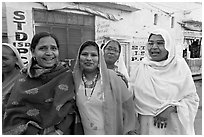 Women wearing hijabs smiling in the street. Jodhpur, Rajasthan, India (black and white)