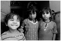 Girls in red dress and blue doors. Jodhpur, Rajasthan, India (black and white)