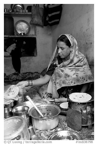 Woman with headscarf stacking chapati bread. Jodhpur, Rajasthan, India (black and white)