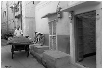 Man with vegetables car in front of painted house. Jodhpur, Rajasthan, India (black and white)