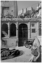 Woman in sari, blue house, and fort in the distance. Jodhpur, Rajasthan, India (black and white)