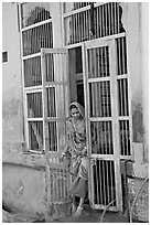 Woman stepping out of door. Jodhpur, Rajasthan, India (black and white)