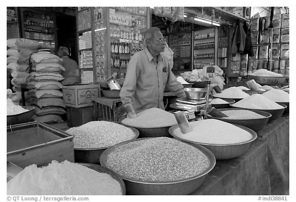 Man in front of grain and spice store, Sardar market. Jodhpur, Rajasthan, India (black and white)