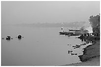 Ganges River at sunset with cremation fire. Varanasi, Uttar Pradesh, India (black and white)