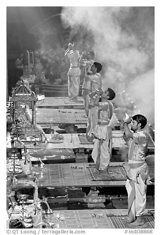 Young priests open Puja ceremony by blowing a conch-shell. Varanasi, Uttar Pradesh, India (black and white)