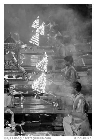 Holy men lifting chandeliers during evening puja. Varanasi, Uttar Pradesh, India (black and white)