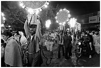 Men carrying bright electric signs during wedding procession. Varanasi, Uttar Pradesh, India ( black and white)