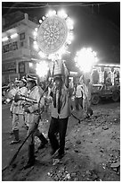Uniformed musicians and men carrying lights during wedding procession. Varanasi, Uttar Pradesh, India ( black and white)