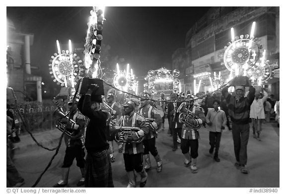 Musicians, men carrying lights, and carriage during wedding procession. Varanasi, Uttar Pradesh, India (black and white)