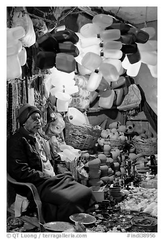 Man selling water jugs and other supplies for pilgrims near the Ganges River. Varanasi, Uttar Pradesh, India (black and white)