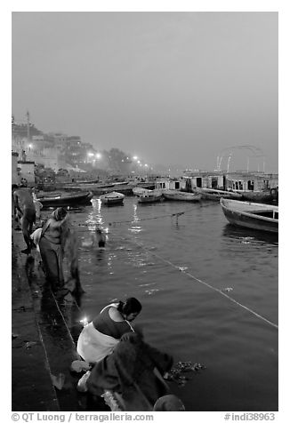 Women soaking clothes in the Ganges River at dawn. Varanasi, Uttar Pradesh, India (black and white)