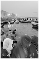 Women on the banks of the Ganga River in rosy dawn light. Varanasi, Uttar Pradesh, India ( black and white)