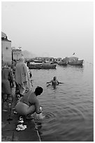 Hindu men dipping in the Ganges River at dawn. Varanasi, Uttar Pradesh, India (black and white)