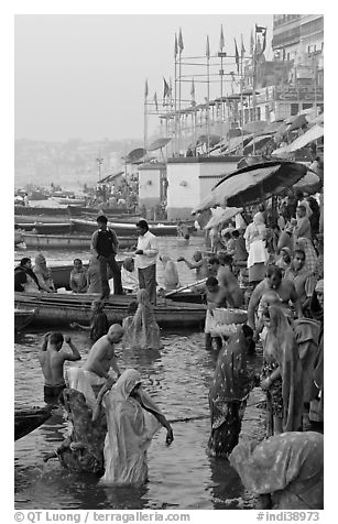 Women standing in Ganga River at sunrise, Dasaswamedh Ghat. Varanasi, Uttar Pradesh, India (black and white)
