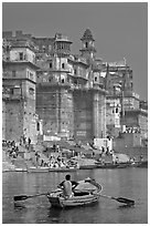 Man rowing boat beneath Munshi Ghat. Varanasi, Uttar Pradesh, India (black and white)