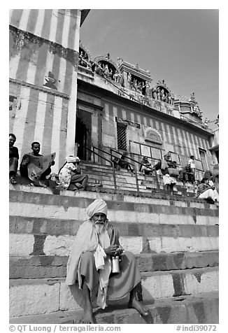 Holy man sitting on temple steps, Kedar Ghat. Varanasi, Uttar Pradesh, India