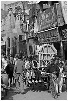 Man moving devotional image and children on rickshaw. Varanasi, Uttar Pradesh, India ( black and white)