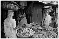 Women with baskets on head buying vegetables, Colaba Market. Mumbai, Maharashtra, India (black and white)