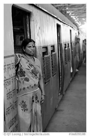 Woman standing at door of suburban train. Mumbai, Maharashtra, India (black and white)