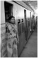 Woman standing at door of suburban train. Mumbai, Maharashtra, India (black and white)