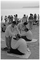 Head rub given by malish-wallah, Chowpatty Beach. Mumbai, Maharashtra, India (black and white)