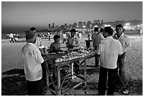 Stall broiling corn at night, Chowpatty Beach. Mumbai, Maharashtra, India (black and white)