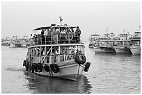 Tour boat loaded with passengers. Mumbai, Maharashtra, India (black and white)