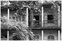 Facade with balconies and man reading. Mumbai, Maharashtra, India (black and white)