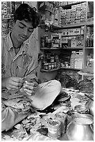 Street vendor preparing a snack with leaves. Mumbai, Maharashtra, India (black and white)