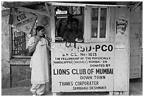 Woman at a street telephone booth. Mumbai, Maharashtra, India (black and white)