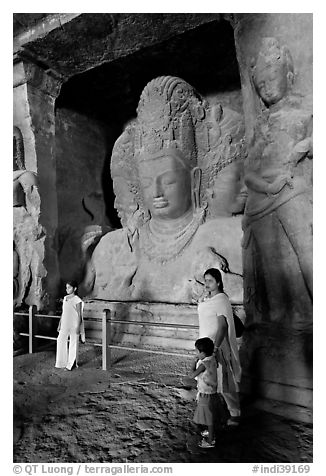 Woman and children standing in front of Mahesh Murti, main  Elephanta cave. Mumbai, Maharashtra, India (black and white)