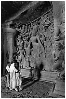 Family looking at Ardhanarishwar Siva sculpture, main Elephanta cave. Mumbai, Maharashtra, India (black and white)