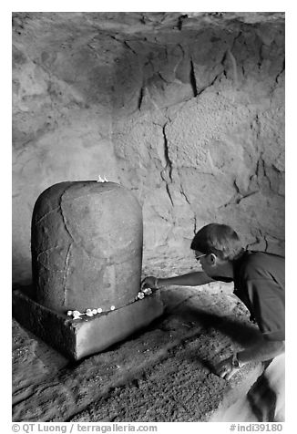 Man venerating a Linga in Shiva shrine, Elephanta Island. Mumbai, Maharashtra, India