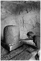 Man venerating a Linga in Shiva shrine, Elephanta Island. Mumbai, Maharashtra, India ( black and white)