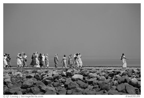 Women walking on  jetty in the distance, Elephanta Island. Mumbai, Maharashtra, India