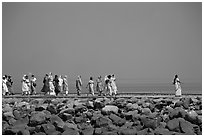 Women walking on  jetty in the distance, Elephanta Island. Mumbai, Maharashtra, India (black and white)