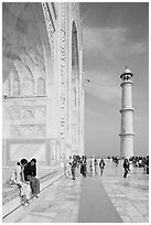 Couple sitting on side pishtaq and tourists strolling on platform, Taj Mahal. Agra, Uttar Pradesh, India (black and white)