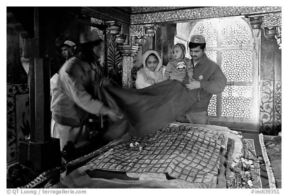 Family making offering inside Shaikh Salim Chishti mausoleum. Fatehpur Sikri, Uttar Pradesh, India (black and white)