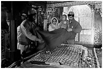 Family making offering inside Shaikh Salim Chishti mausoleum. Fatehpur Sikri, Uttar Pradesh, India (black and white)