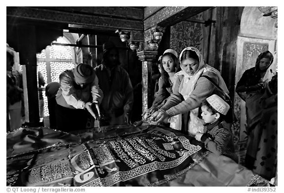 Women making offerings on Shaikh Salim Chishti tomb. Fatehpur Sikri, Uttar Pradesh, India (black and white)