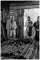 Family making offering on Shaikh Salim Chishti tomb. Fatehpur Sikri, Uttar Pradesh, India (black and white)