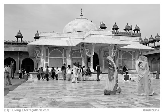 Two women walking outside the white marble  Shaikh Salim Chishti tomb. Fatehpur Sikri, Uttar Pradesh, India (black and white)