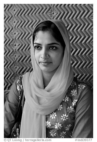 Young woman with bright scarf, in front of Rumi Sultana motifs. Fatehpur Sikri, Uttar Pradesh, India (black and white)