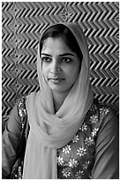 Young woman with bright scarf, in front of Rumi Sultana motifs. Fatehpur Sikri, Uttar Pradesh, India (black and white)